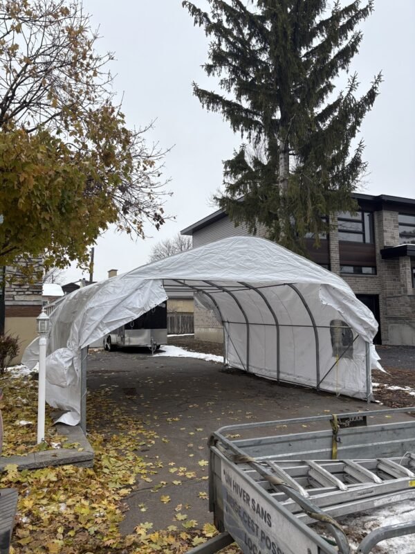 Abri d'auto installé dans une entrée bordée d'arbres